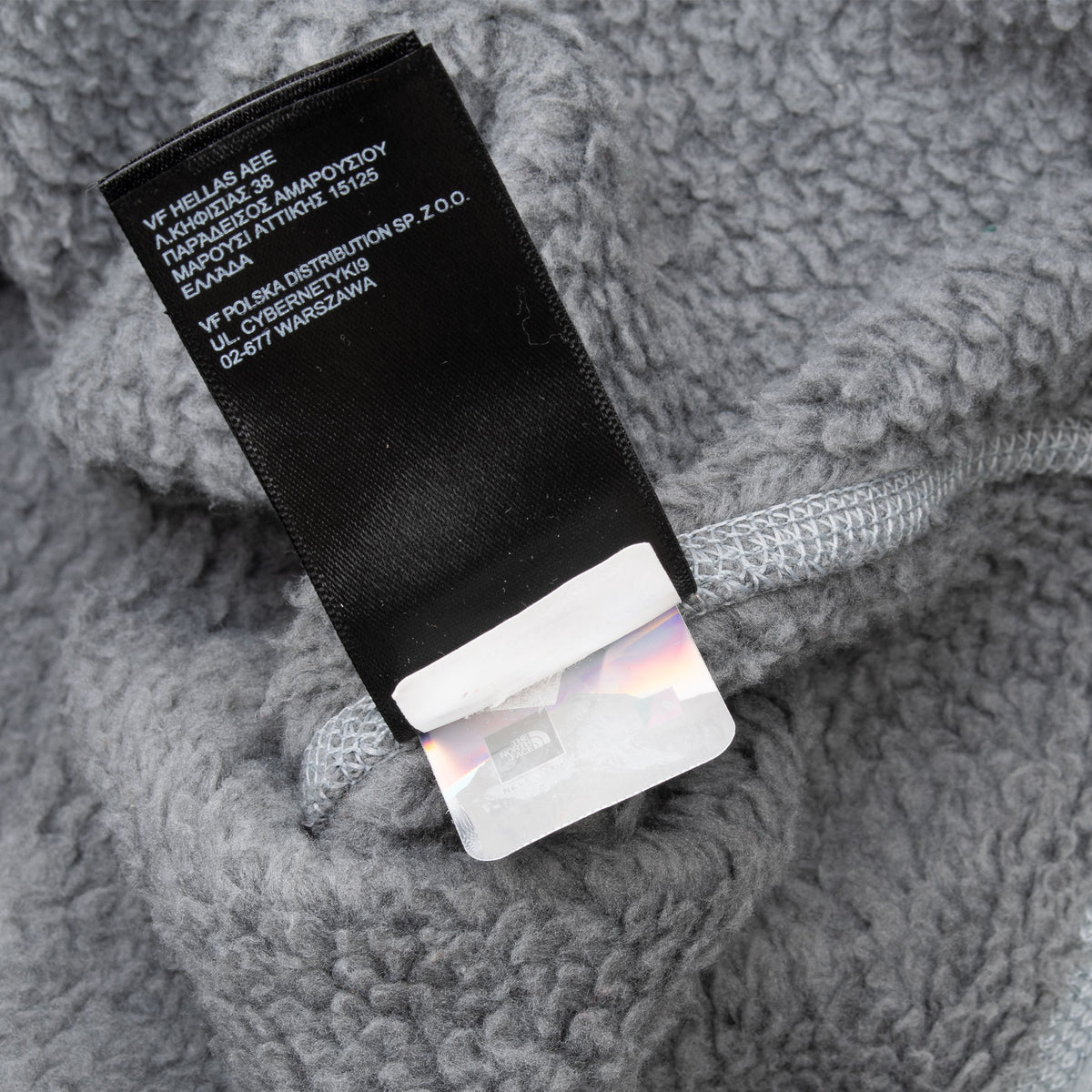 Close-up of care labels inside The North Face grey jacket