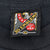 Close-up of 3D Emblem XL eagle neck tag on black T-shirt