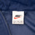 Nike neck label showing size XXL and Made in Indonesia inside blue windbreaker