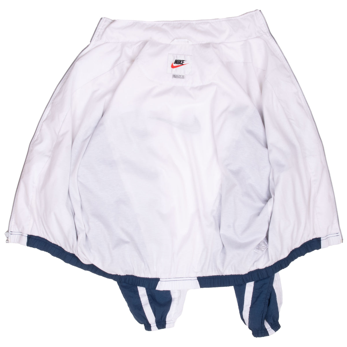 Open Nike windbreaker showing white interior lining, neck label, and navy trim
