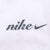Close-up of gray Nike script and Swoosh embroidery on white fabric