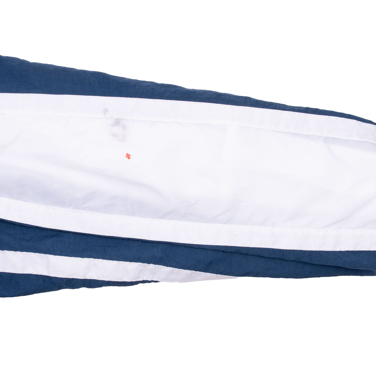 Close-up of white and navy sleeve panel with faint marks and a small orange spot