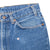 Close-up of the front pocket, belt loops and small arrow marker on the blue denim