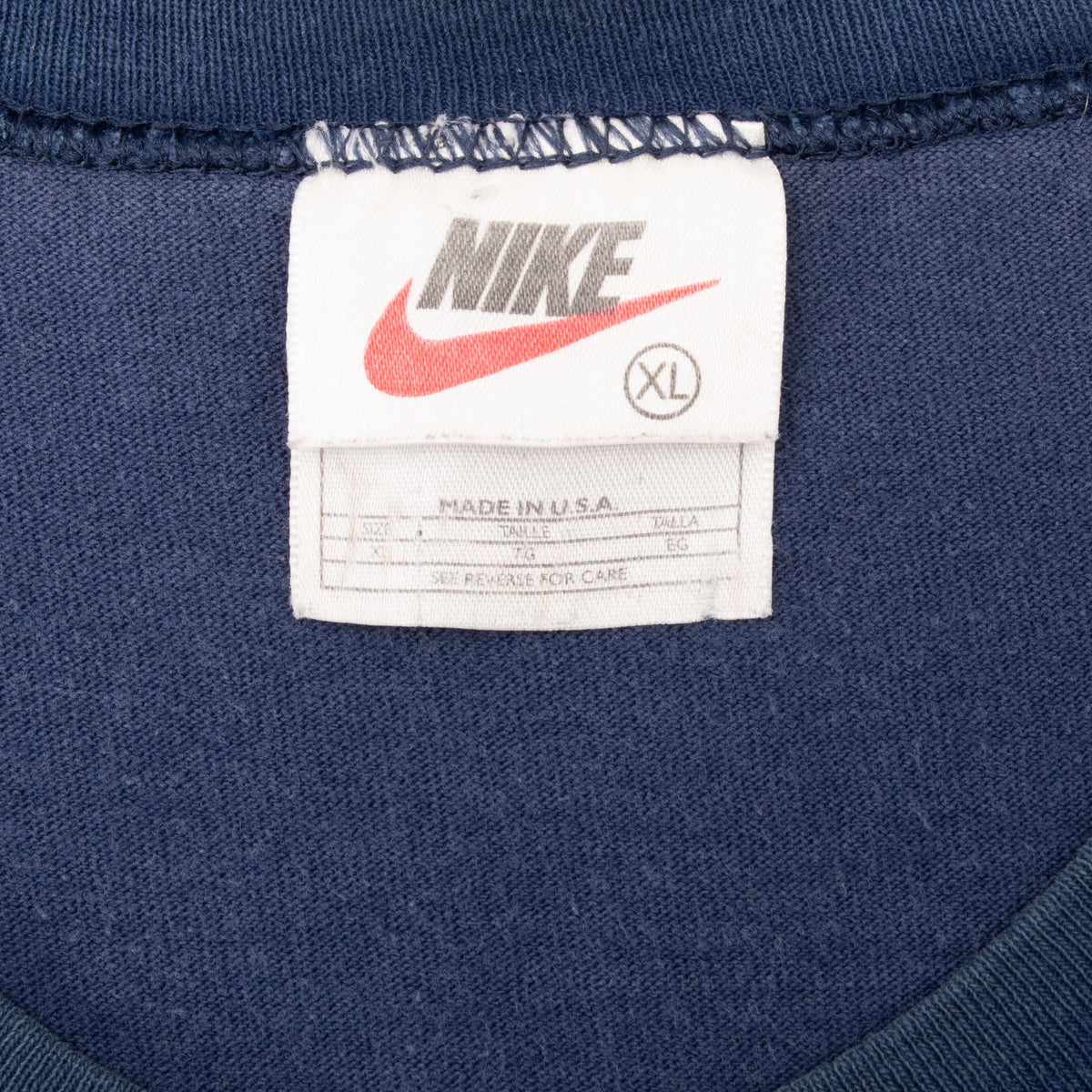 Nike neck tag marked XL and Made in USA inside navy sleeveless shirt