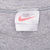 Close-up of Nike neck tag and ribbed crew neckline on grey tank top