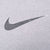 Close-up of dark Nike Swoosh print on grey fabric