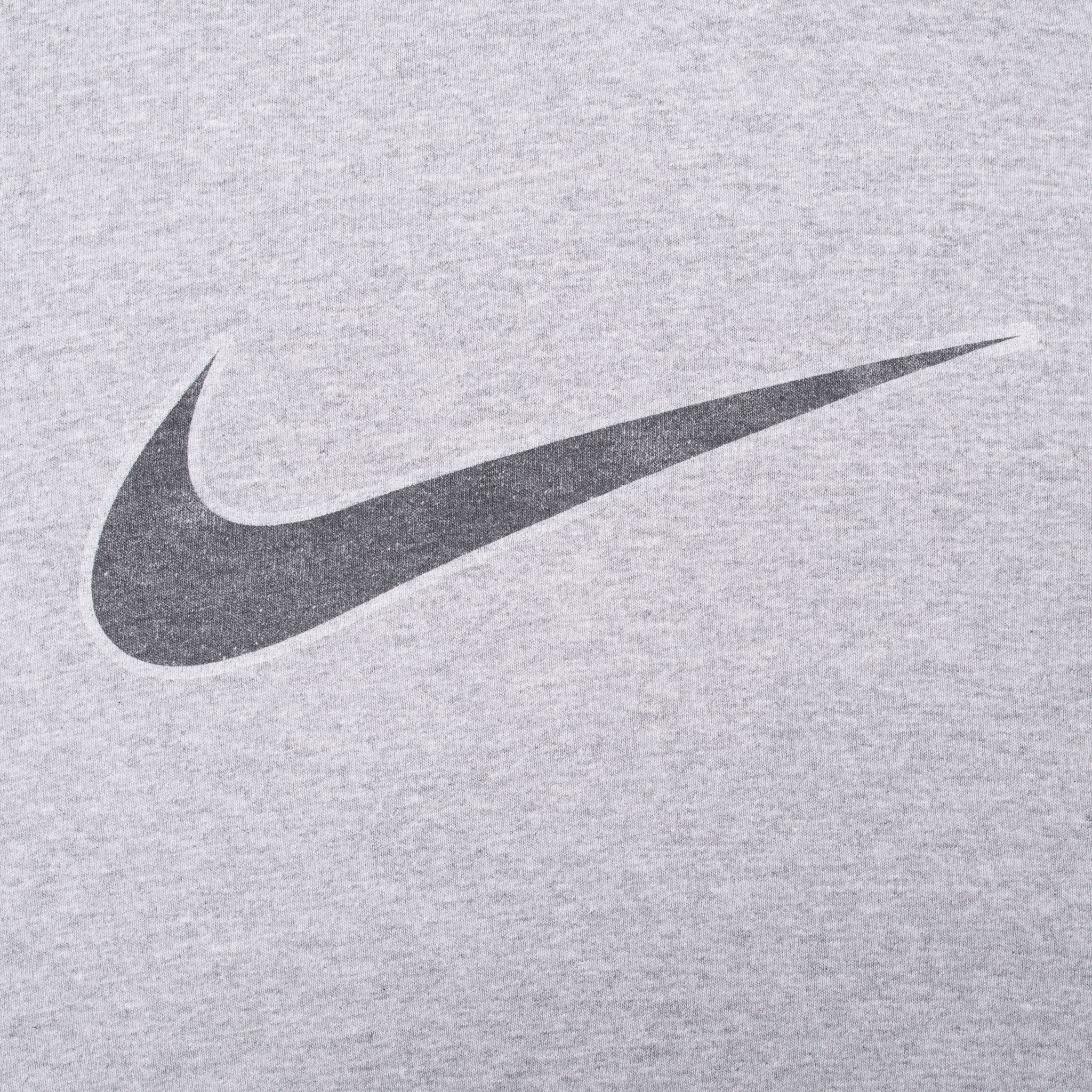Close-up of dark Nike Swoosh print on grey fabric