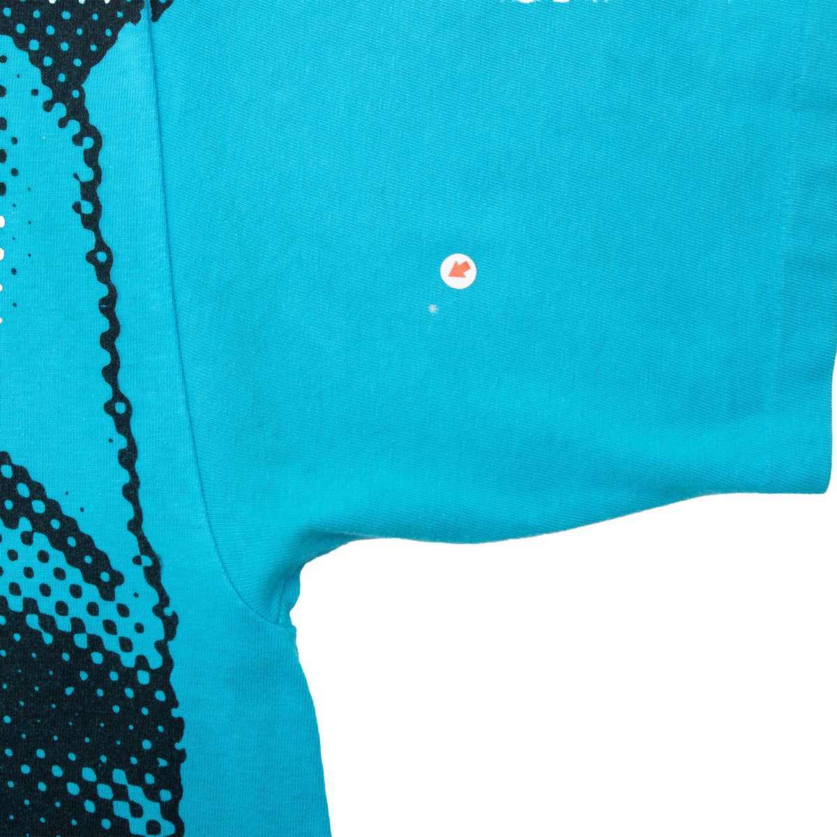 Turquoise sleeve and side-seam detail with a small marked flaw
