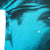 Close-up of black halftone print on turquoise fabric with a small marked flaw