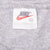 Nike neck tag with orange Swoosh and XXL size marking inside grey T-shirt