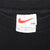 Nike neck tag with red Swoosh and XXL size marking on black T-shirt