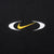 Close-up of yellow Nike Swoosh embroidery framed by white oval accents