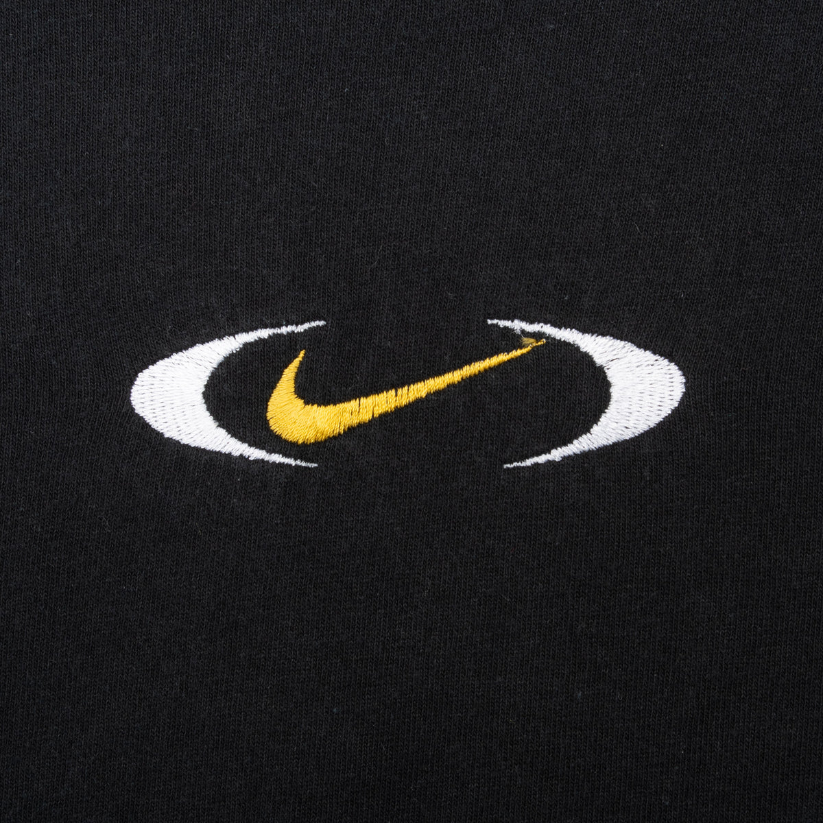 Close-up of yellow Nike Swoosh embroidery framed by white oval accents
