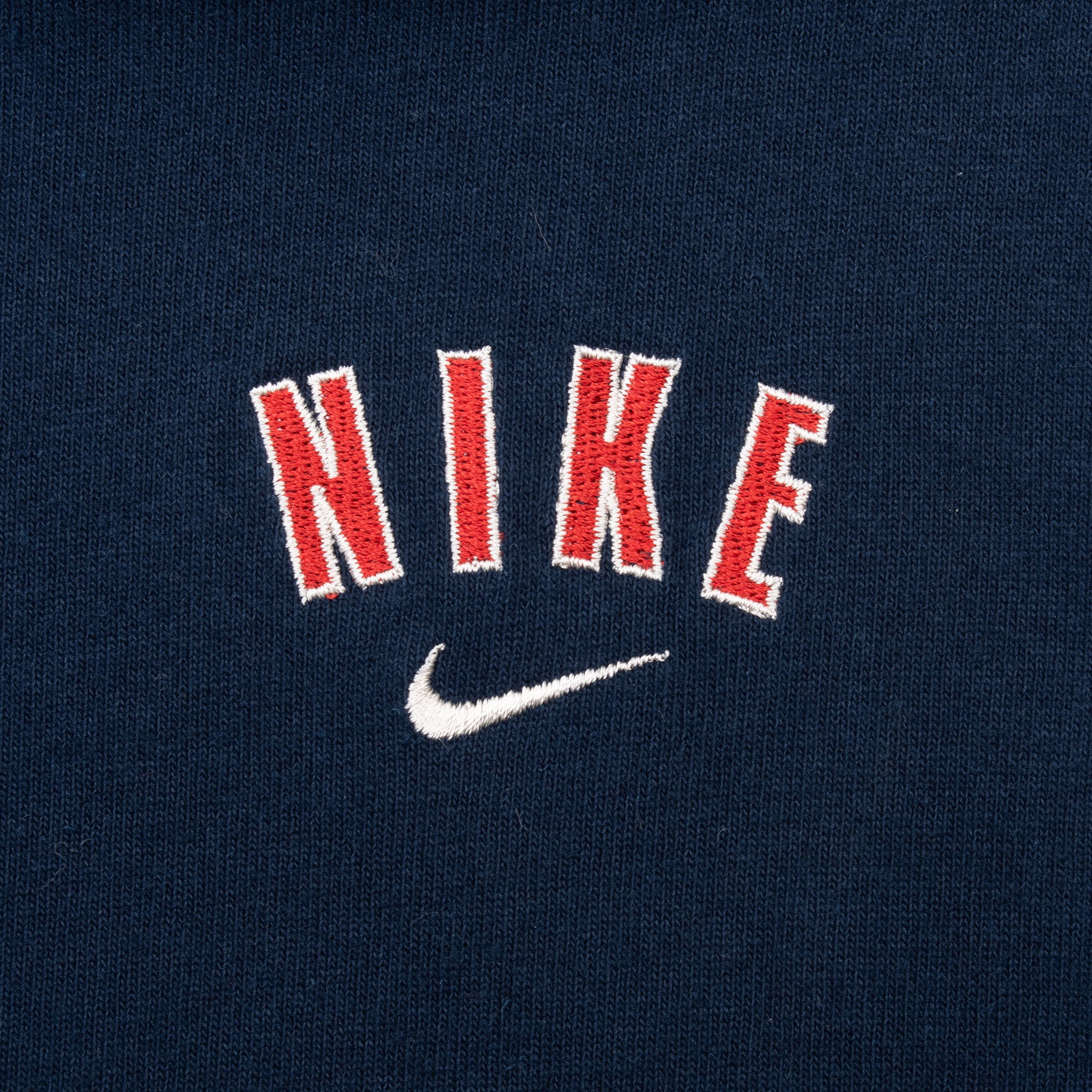 Close-up of red and white Nike wordmark embroidery with white Swoosh