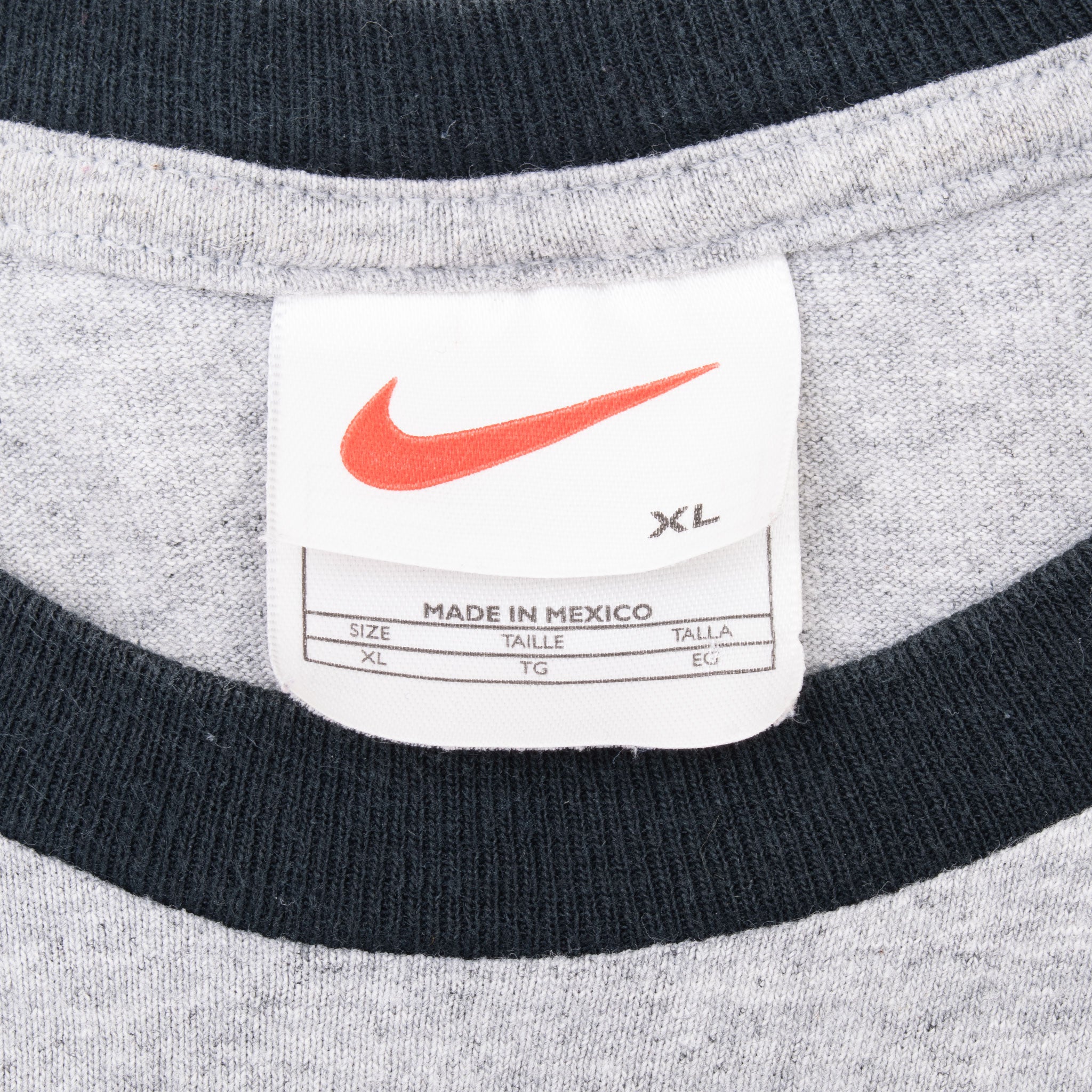 Close-up of Nike neck tag with red Swoosh inside black-trimmed collar