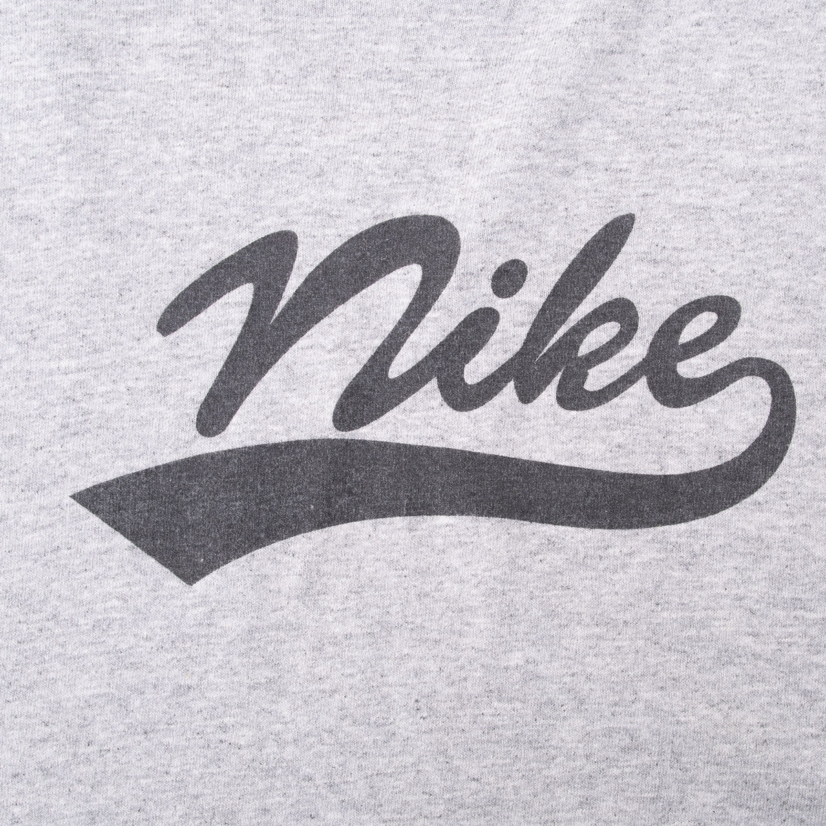 Close-up of black script Nike spellout and underline chest graphic on grey fabric