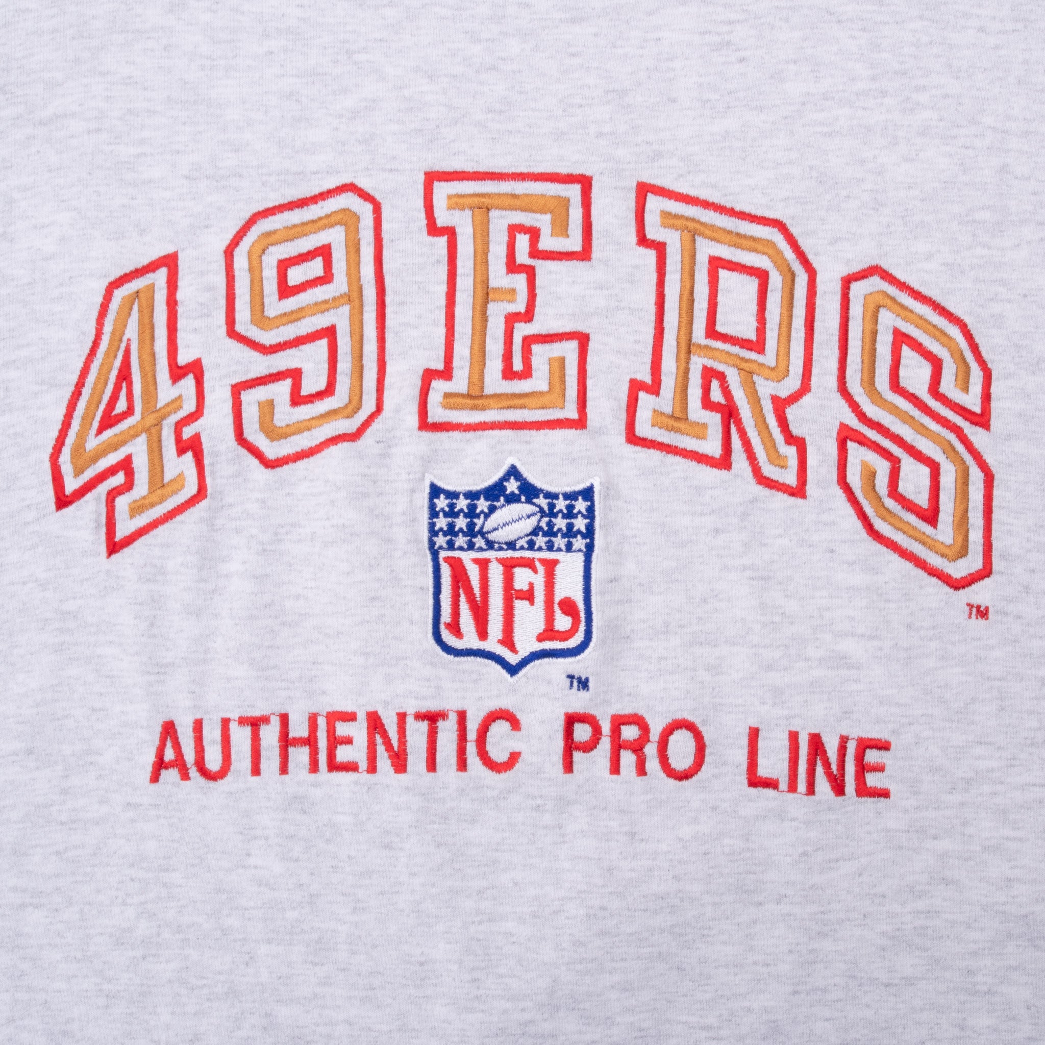 Close-up of red and gold 49ers lettering and NFL shield embroidery