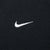 Close-up of white embroidered Nike Swoosh on black chest fabric