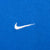 Close-up of white embroidered Nike Swoosh on blue T-shirt