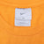 Nike neck tag with Swoosh and large size marking inside orange T-shirt
