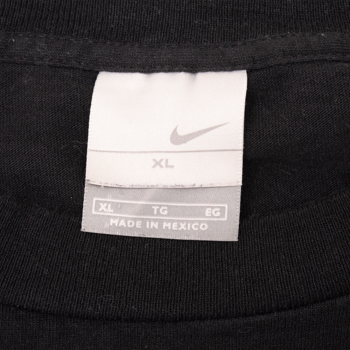 Close-up of Nike neck tag marked XL inside black T-shirt