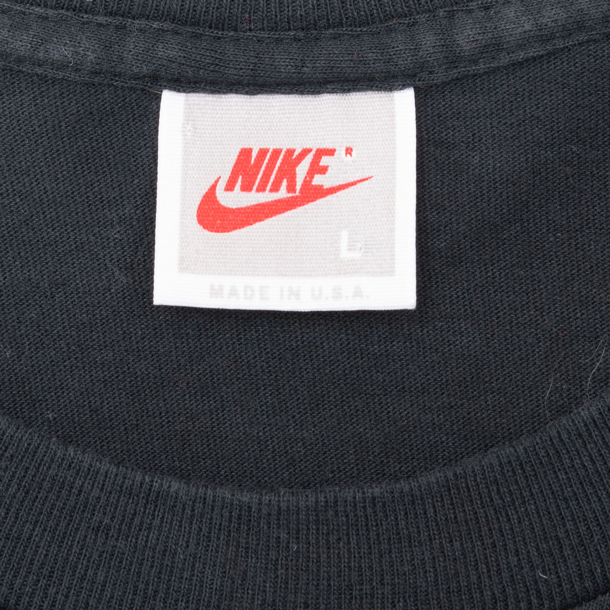 Nike neck tag with red Swoosh, size medium and Made in USA text