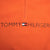 Close-up of embroidered Tommy Hilfiger chest logo and quarter zip on orange fleece