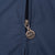 Close-up of Nike Swoosh medallion zipper pull on navy windbreaker