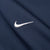 Close-up of white embroidered Nike Swoosh on navy jacket fabric