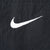 Close-up of white embroidered Nike Swoosh on black fabric