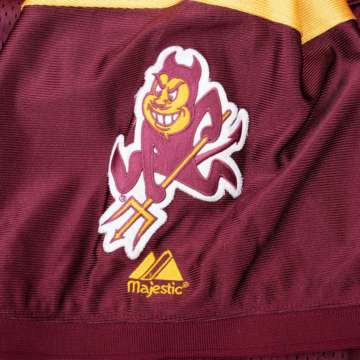 Sparky the Sun Devil and Majestic sleeve embroidery on maroon fabric
