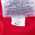 Close-up of interior product and care tags with Nike Swoosh on red jersey fabric