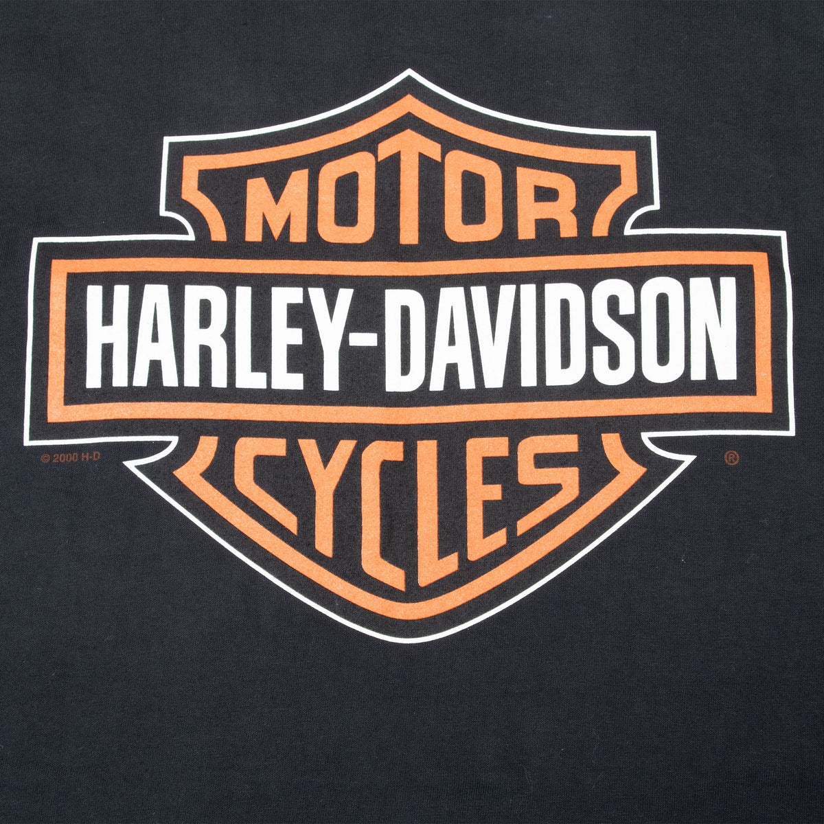 Close-up of orange and white Harley-Davidson Motor Cycles shield print