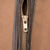 Close-up of metal front zipper and dark contrast trim on brown Carhartt vest