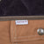 Close-up of Carhartt fabric tab, branded snap and dark quilted shoulder panel