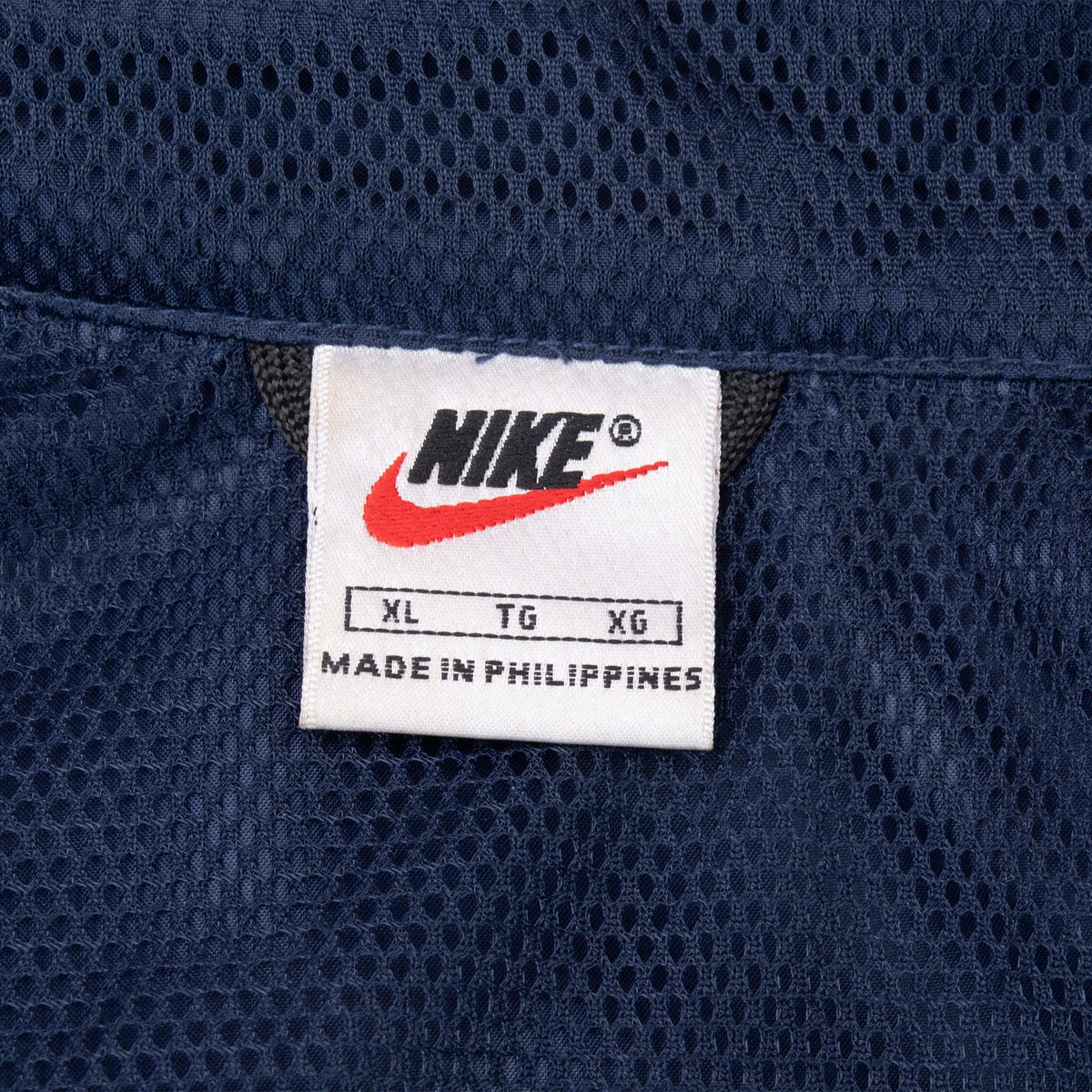 Nike XL neck label against navy mesh-textured lining