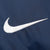 Close-up of white embroidered Nike Swoosh on navy fabric