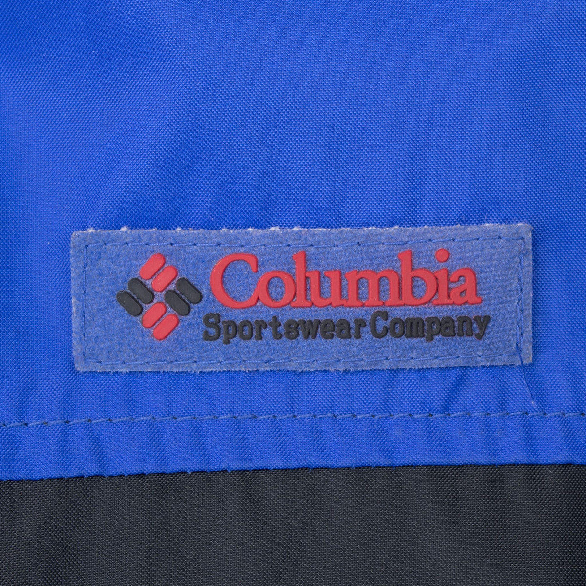 Close-up of Columbia Sportswear Company logo patch on blue jacket chest