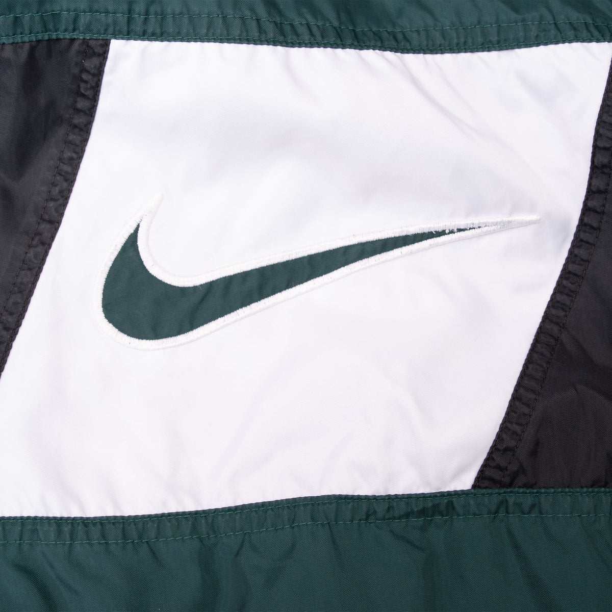 Close-up of green Nike Swoosh on white front chest panel