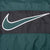 Close-up of oversized green and white outlined Nike Swoosh on black back panel