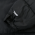 Close-up of white 700 embroidery and adjustable cuff on black jacket sleeve