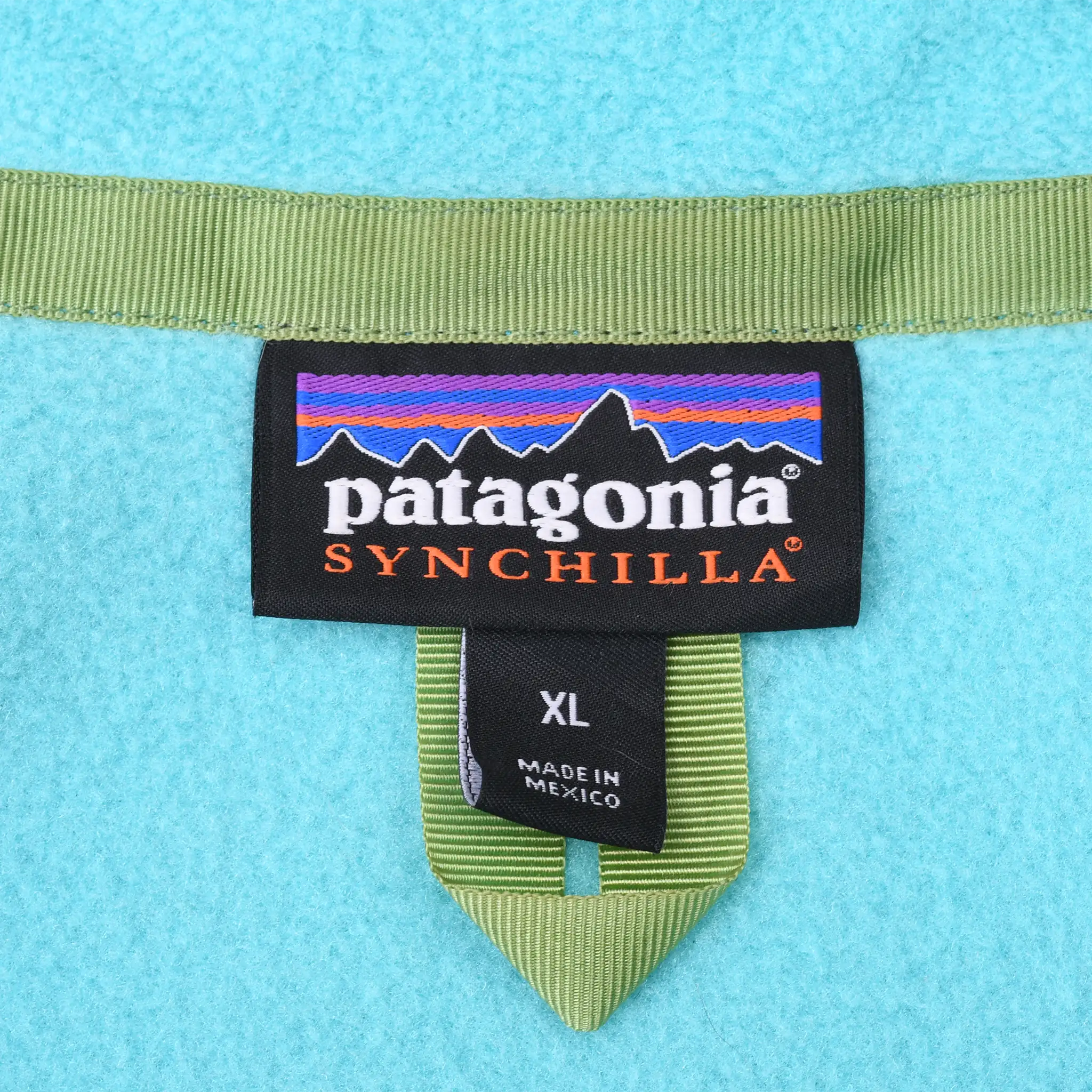 Patagonia Synchilla neck label and XL size tag on turquoise fleece