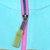 Close-up of pink front zipper with green fabric pull on turquoise fleece