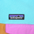 Patagonia logo patch above the pink chest pocket flap on turquoise fleece