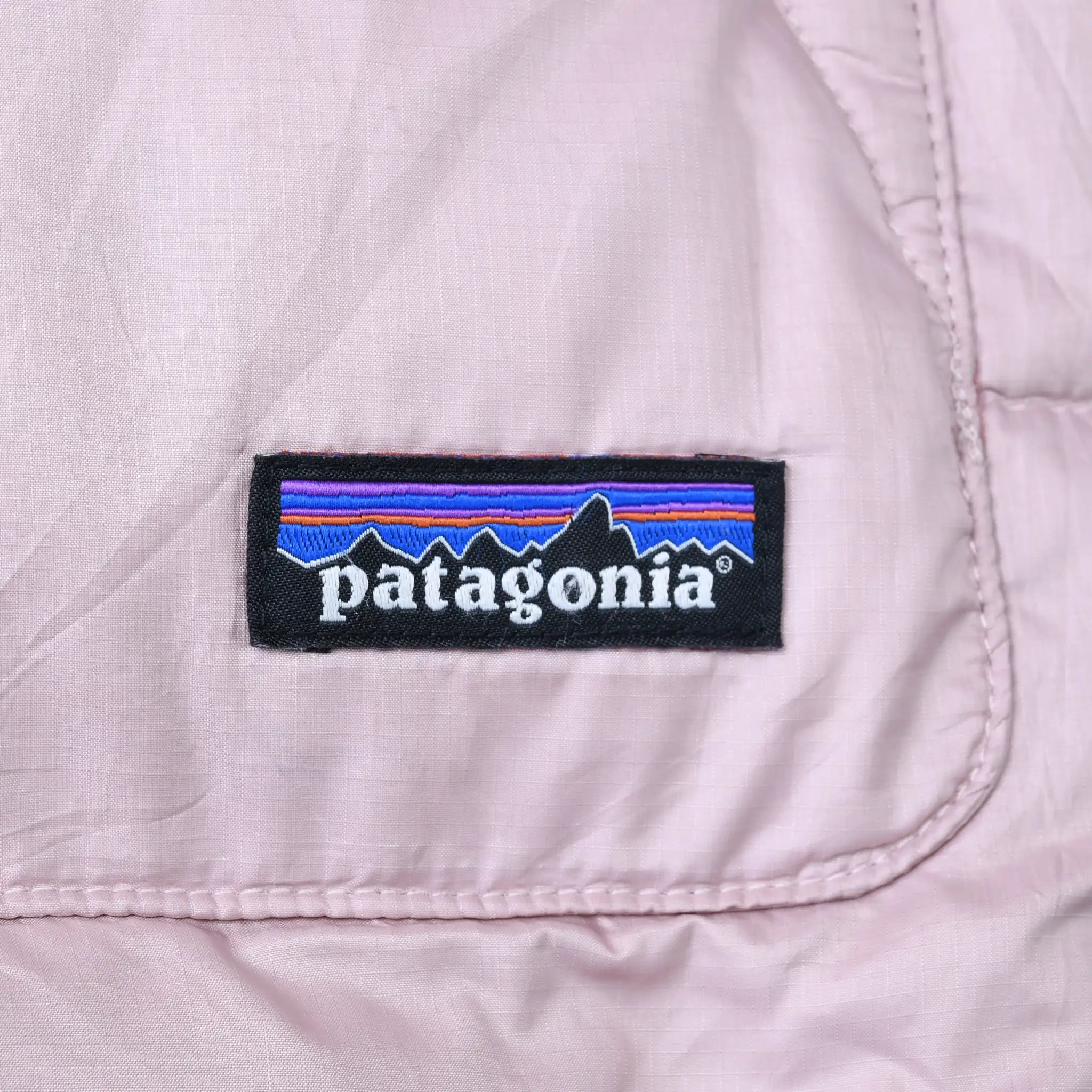 Patagonia woven logo patch on pale pink puffer fabric