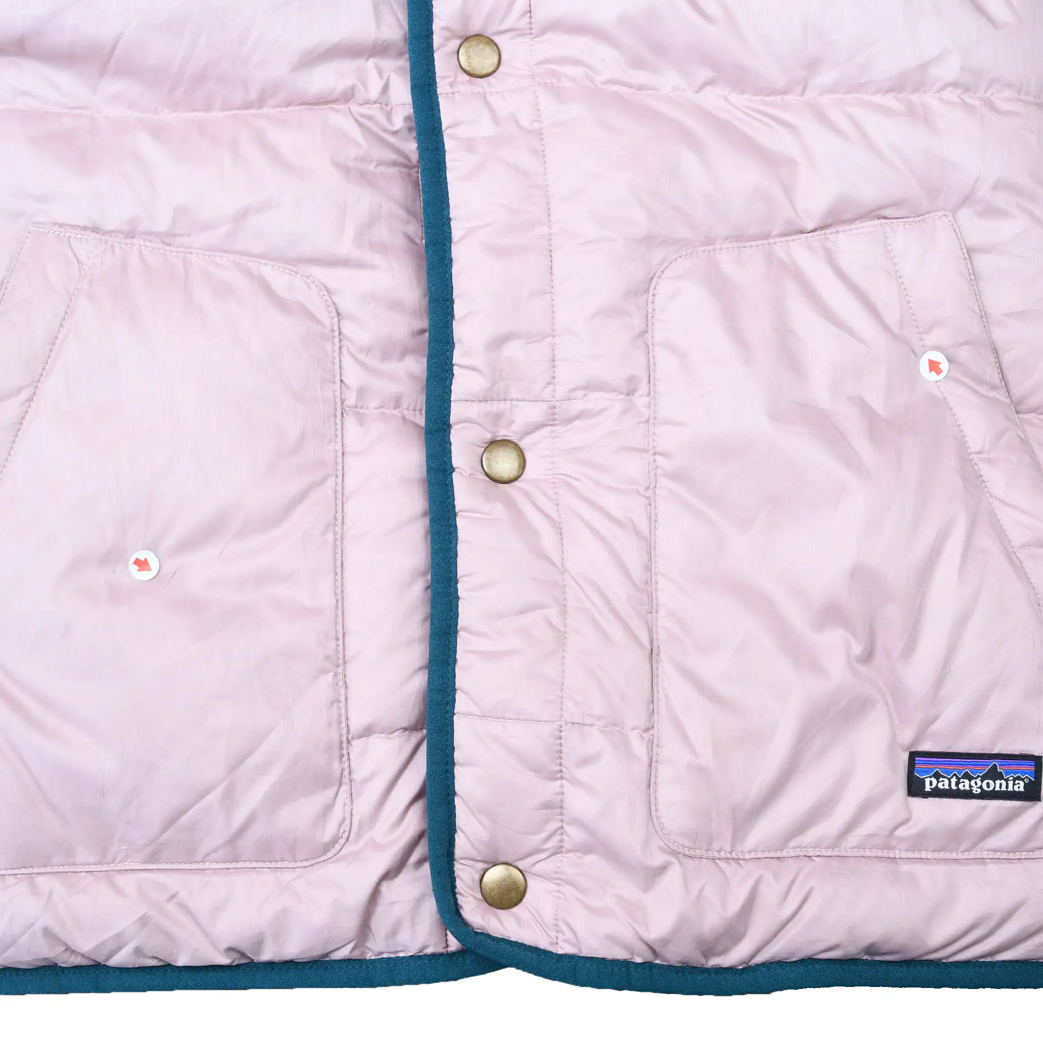Pale pink puffer front detail with snap closure, two pockets, teal trim, and Patagonia patch