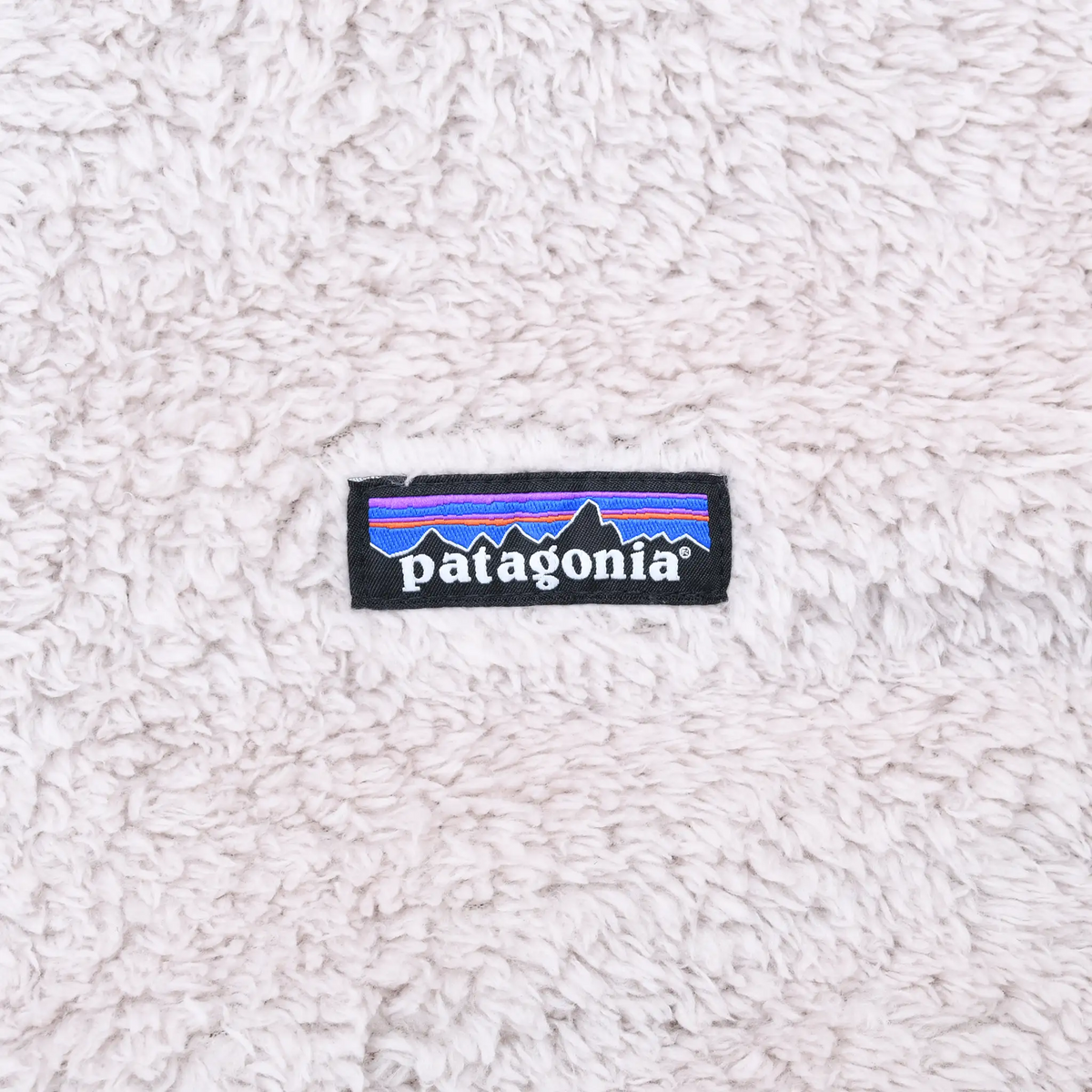 Patagonia logo patch on beige plush fleece fabric
