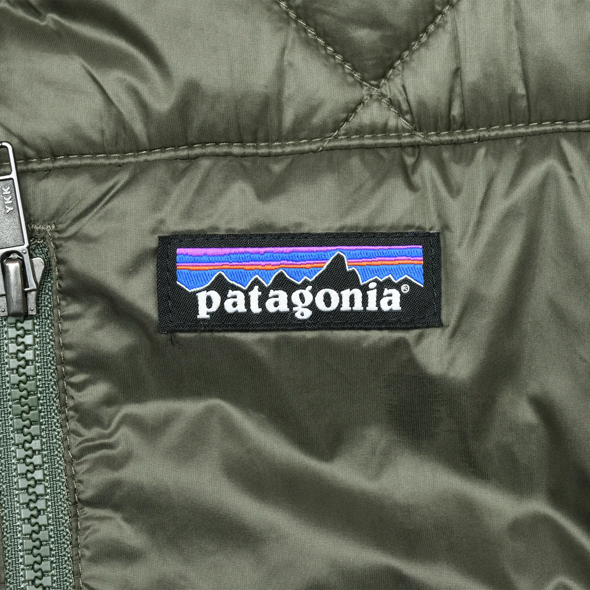 Close-up of Patagonia logo patch on green quilted chest