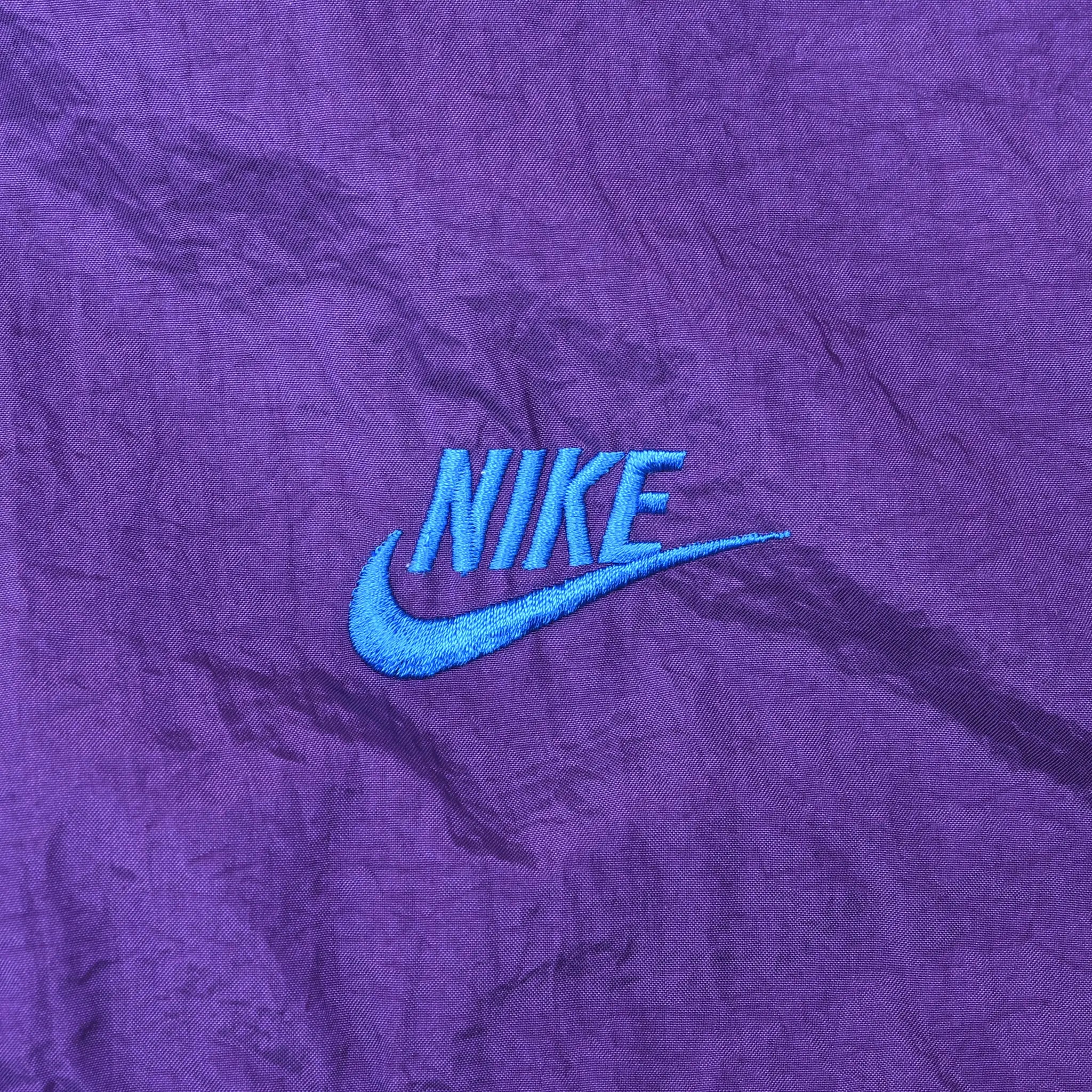 Blue Nike wordmark and Swoosh embroidery on purple chest
