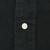 Close-up of white button and stitching on black shirt fabric